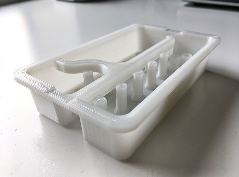 Translucent 3D-printed self-watering reservoir insert showing wicking columns and water channels