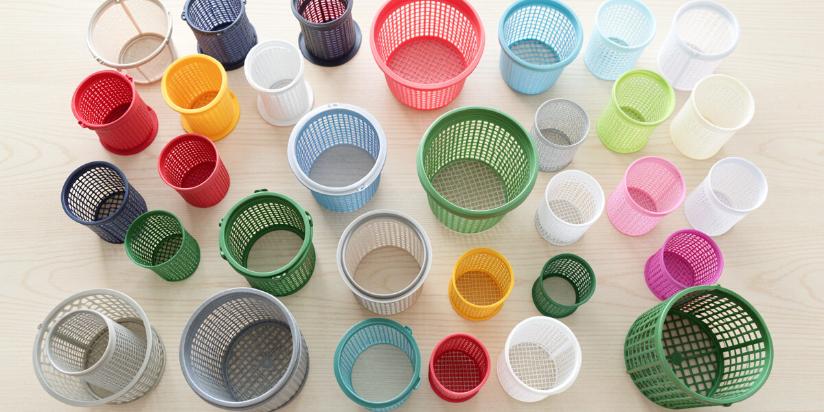 Assortment of hydroponic net cups and mesh baskets in different sizes on a pale wooden table